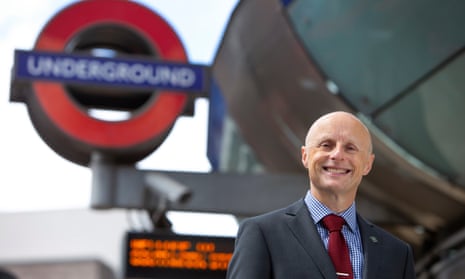 Andy Byford smiling with a large outdoors London Underground sign behind him