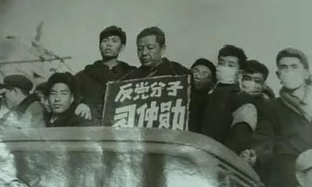 Xi Zhongxun carries a placard while surrounded by a mob of young men