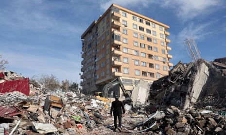 A man walks across the rubble of collapsed building toward in Kahramanmaras, close to the quake's centre, on 7 February 2023. 