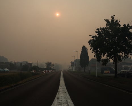 The entrance of the town of Biscarosse, southwestern France, with a sky turned hazy yellowish-grey by the smoke of a wildfire spreading through the surrounding forest.