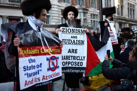 Members of the Ultra-Orthodox Jewish community hold placards as they take part in a ‘National March For Palestine’ in central London on November 25, 2023, calling for a ceasefire in the conflict between Israel and Hamas.