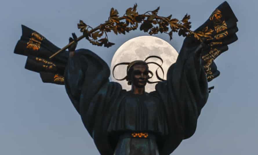 Full moon rises over a sculpture in Independence Square, Kyiv.