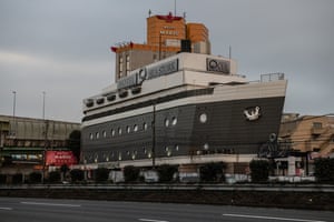 The Hotel Q Sea Stork, shaped like a cruise ship, looms over a nearby highway in Machida