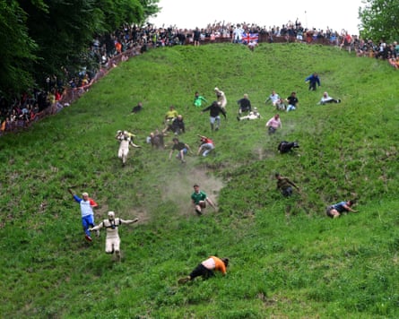 People rolling down Cooper’s Hill