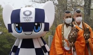 Tokyo 2020 Olympic Games mascot Miraitowa and Buddhist monks wearing protective face masks attend a ceremony to unveil a display of Olympic Symbol on Mt. Takao in Hachioji, west of Tokyo, Wednesday, 14 April 2021, to mark 100 days before the start of the Olympic Games.