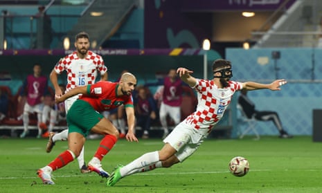 Croatia's Josko Gvardiol goes down under a challenge from Morocco's Sofyan Amrabat in the penalty area.