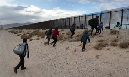 Immigrants approach the US-Mexico border fence in El Paso, Texas.