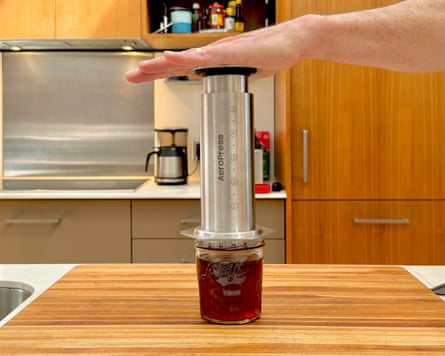 A person making coffee with an aeropress steel