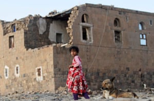 A girl walks near her house which was destroyed in an airstrike on Yemen by the Saudi-led coalition in the village of Faj Attan.
