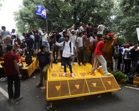 Crowd of protesters stood on knocked-over yellow barricades