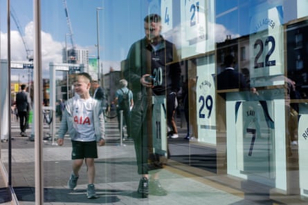 A young Spurs fan looks through a window at signed shirts from the current squad hanging in the main atrium of the stadium