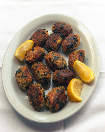 spinach croquettes on a plate with lemon wedges