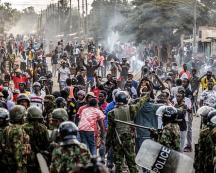 Crowds of people and police with smoke in air