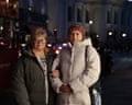 Nataliya Rumyantseva and her mother, Valentyna Klymova, stand on a dark street in winter coats with their arms linked.