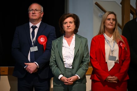 Eluned Morgan, centre, with two other candidates wearing red rosettes