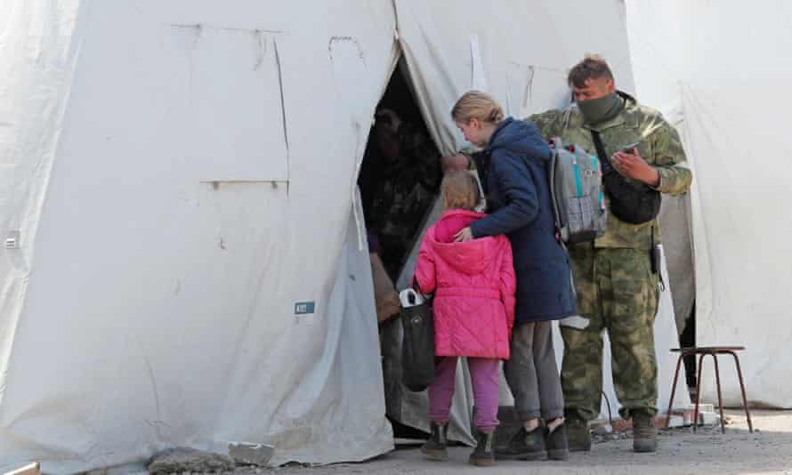 Civilians who left the area near Azovstal steel plant in Mariupol enter a tent at a temporary accommodation centre in Bezimenne