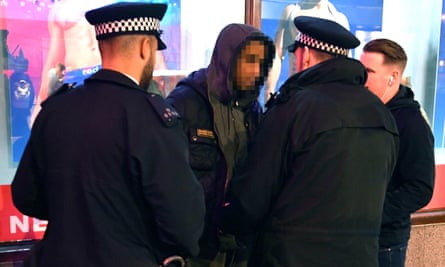 Metropolitan police officers carrying out a stop-and-search on a man in 2019.