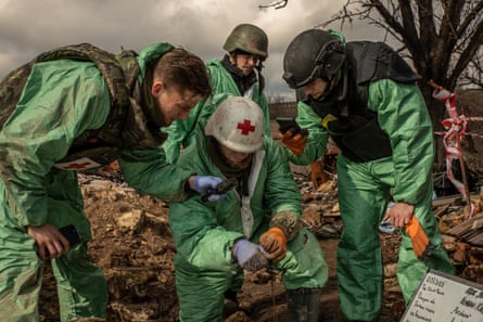 Volunteers of a group called Black Tulip examine personal belongings of the two Russian soldiers whose bodies were collected in Krasnopillia