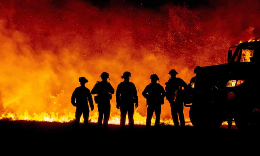 Butte County firefighters watch flames spread rapidly on a road during the Bear Fire in Oroville, California.