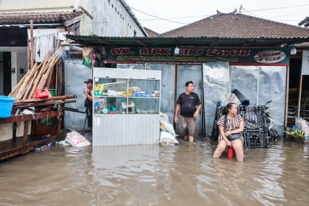 A flooded shop with people sitting outside