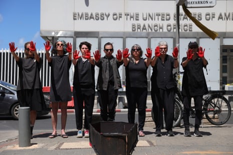 Demonstrators, among them family members of Israelis held by Hamas in Gaza, stand with red paint on their hands in front of a mock coffin during a protest calling for an end of the war and the immediate release of all hostages, outside the US embassy in Tel Aviv, 7 May.