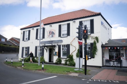 Outside view of the pub, with its white walls and a painting of a horse above its name sign