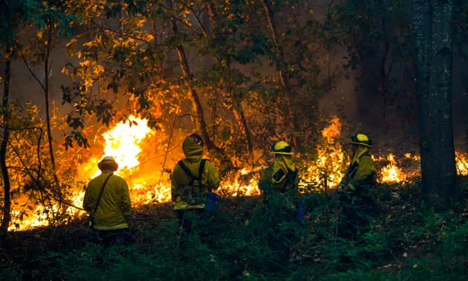 Firefighters at a house during the CZU Lightning Complex fire on Sunday in Boulder Creek, California.