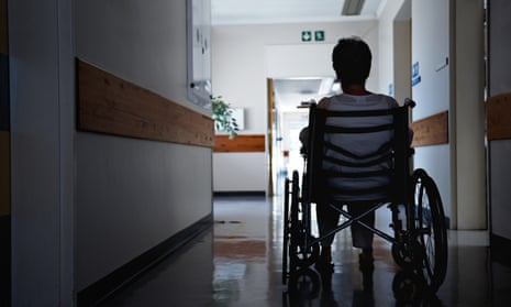 Rearview shot of a senior woman sitting in a wheelchair in a corridor