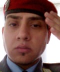 Headshot of a man wearing a dark red beret, saluting