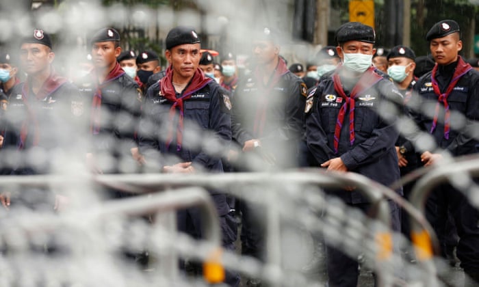 Police officers stand in lines as they close a road near Ratchaprasong junction in Bangkok