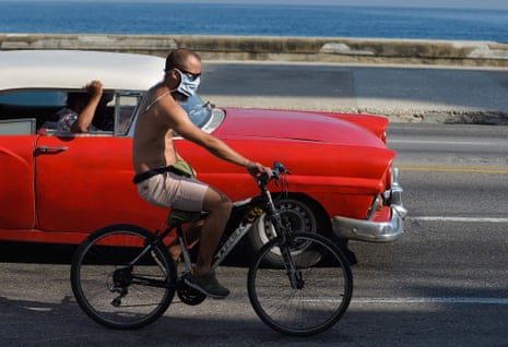 A man wearing a face mask against the spread coronavirus rides his bicycle in Havana on 8 September, 2020.