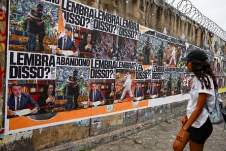 A woman looks at banners depicting former president Jair Bolsonaro, with the words: “Remember that?”