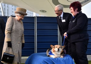 Queen Elizabeth II and Paul O’Grady look upon a corgi at the Battersea Dogs and Cats Home in London in 2015