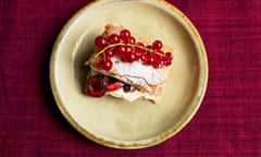 A red fruit filo pastry oozing with cream and topped with a sprig of redcurrants