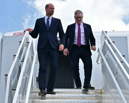 Prince William and Keir Starmer walk down steps from a plane