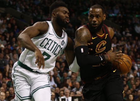 LeBron James, wearing a black Cleveland Cavaliers jersey, makes a drive past Jaylen Brown, wearing a white Boston Celtics jersey.