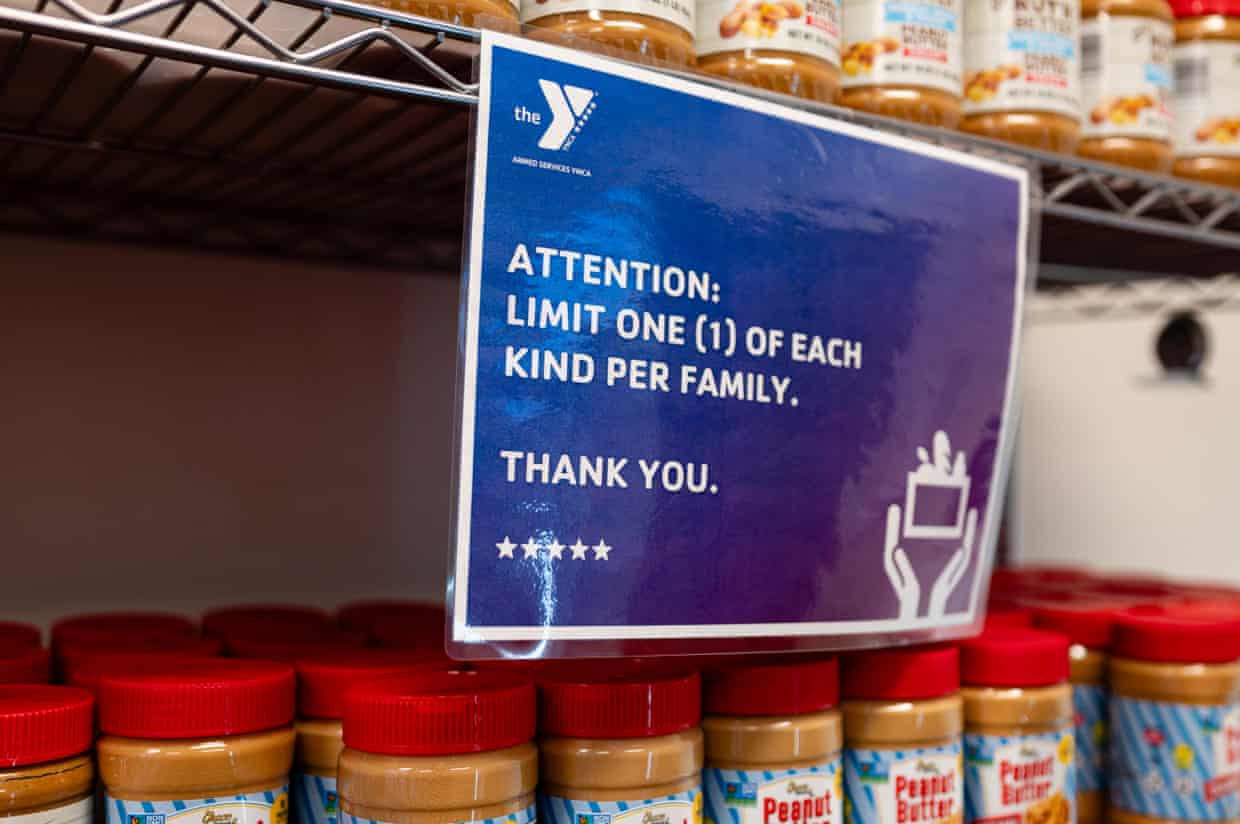 A sign on a shelf filled with jars of peanut butter tells people to ‘limit one of each kind per family’