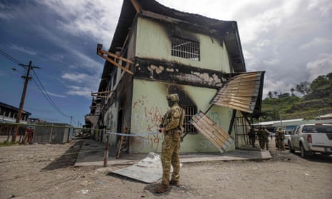 Australian soldiers patrol the burnt-out area in Honiara's Chinatown on 2 December 2021, after riots erupted in the Solomon Islands’ capital. 