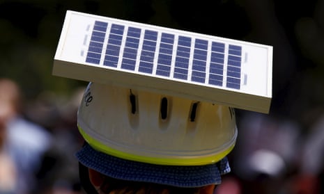 A cyclist wears a helmet with a solar panel attached as he participates in a march along the main street of Adelaide.