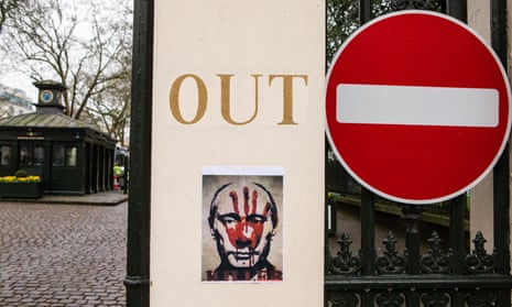 A protest poster of Vladimir Putin at the entrance to Kensington Palace Gardens in London, March 2022