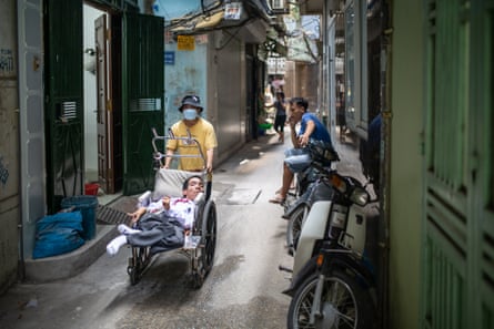 Dinh Quoc Tuan wordt door een smal straatje geholpen.