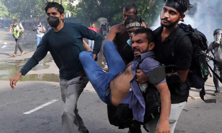 University students carry an injured man after police used water cannons to disperse protests amid economic crisis in Colombo, Sri Lanka, on 19 May.