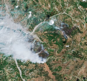 Smoke plumes over patches of completely charred land.