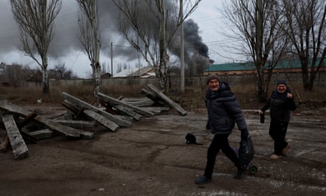Volodymyr, 61, and Nataliia Bolias, 51, walk past an industrial building hit by a Russian missile strike in Bakhmut, Ukraine.