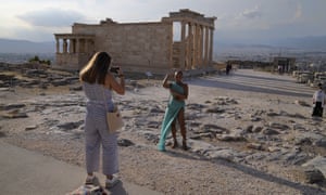Tourists take photos at the Parthenon temple at the Acropolis hill in Athens earlier this month.