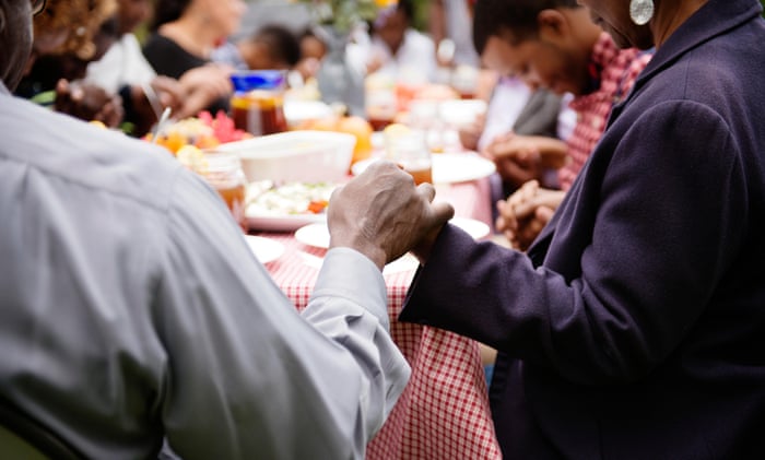 Family members holding hands while saying grace