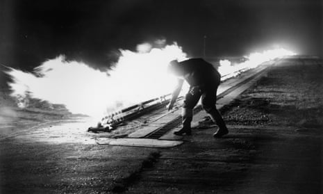 A member of staff at Blackbushe Airport, Surrey ignites burners in preparation for aircraft to take off in fog in November 1952.