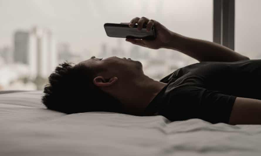 A man scrolls through his smartphone in Bangkok, Thailand.