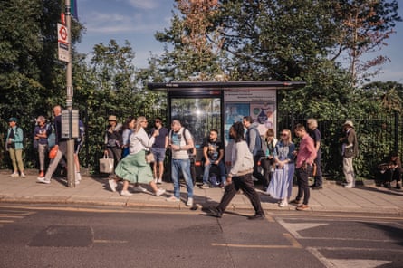 People wait or walk pass a bus stop outside the All England Club in London during Wimbledon