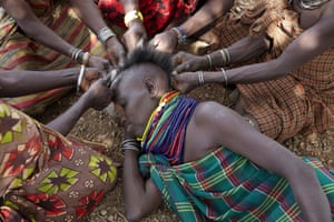 Alaar Lokadelio has her hair styled as women gather in the shade in Kachoda, Lokitaung district, Turkana, Kenya, in 2011. In that year, the pastoralist communities of Turkana were experiencing the longest period of drought in their history. With their livestock dying, they struggled to feed themselves, and depended on NGO food aid. Drought returned once more in 2019